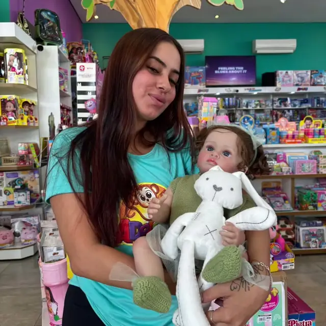 Atendente com uma boneca no corredor da loja