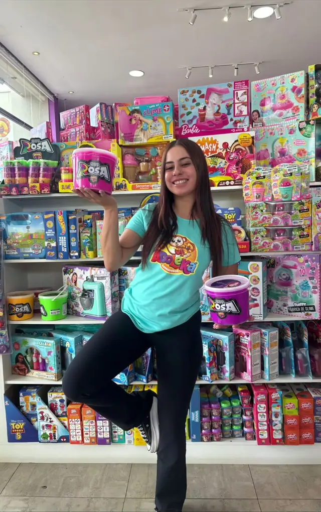 Atendente da loja posando entre as prateleiras de brinquedos
